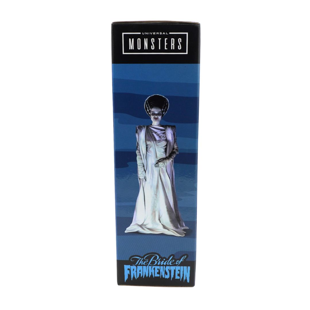 A tall rectangular product box for Universal Monsters' 'The Bride of Frankenstein' featuring a blue striped background, an illustration of a woman in a white gown, and the title at the bottom.