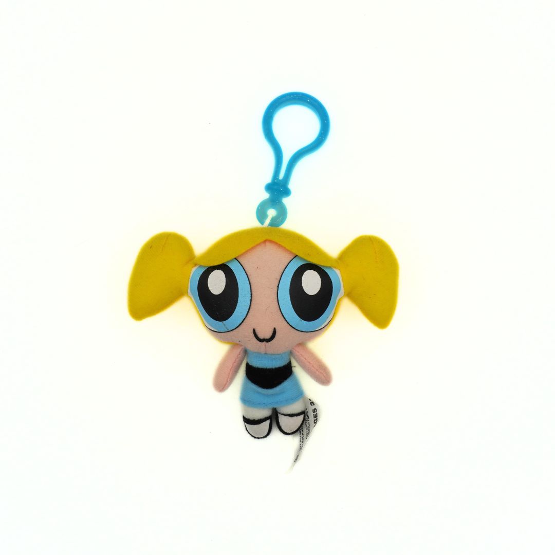 Plush keychain of a cartoon character with yellow hair and blue eyes on a white background