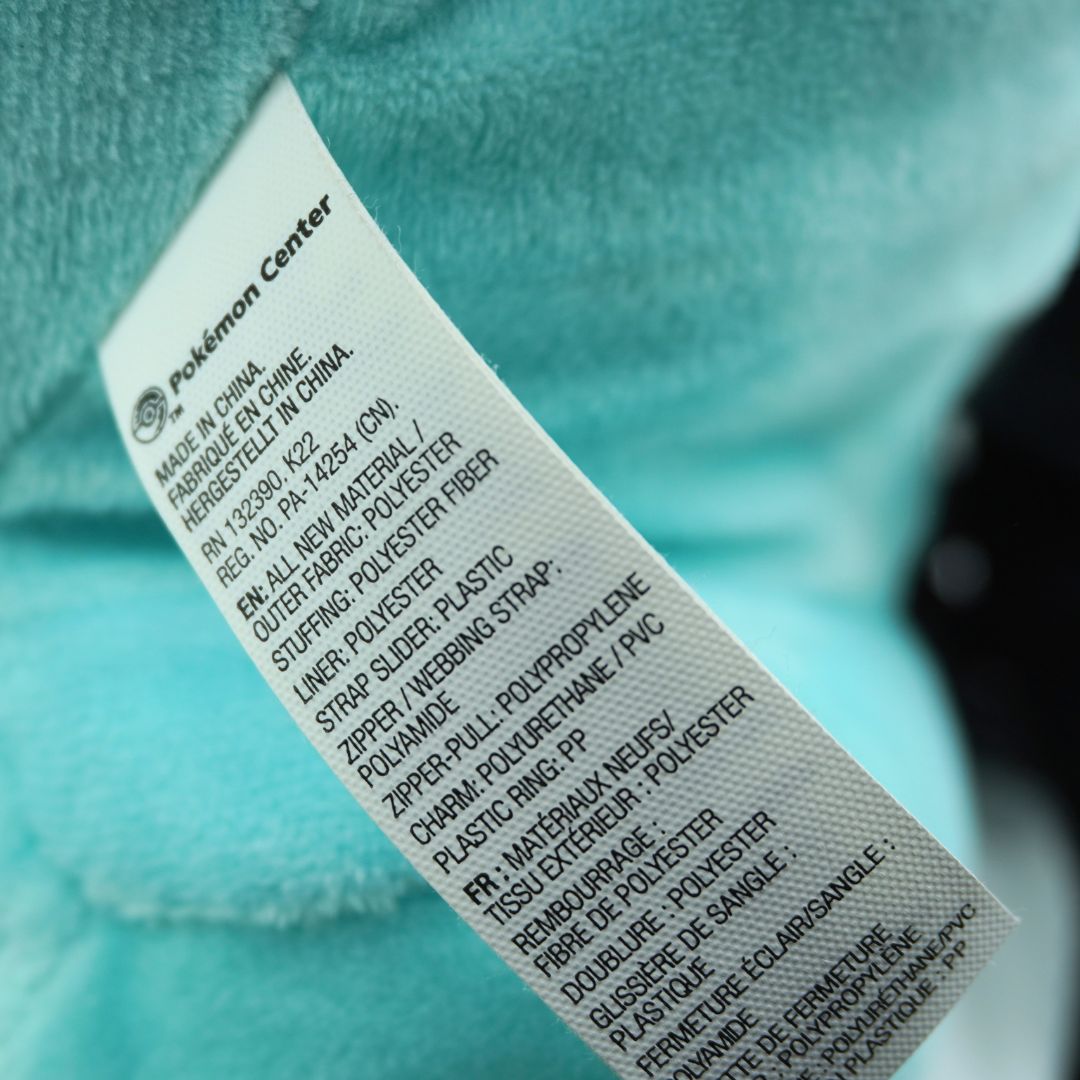 Close-up of a label on a turquoise item with text.