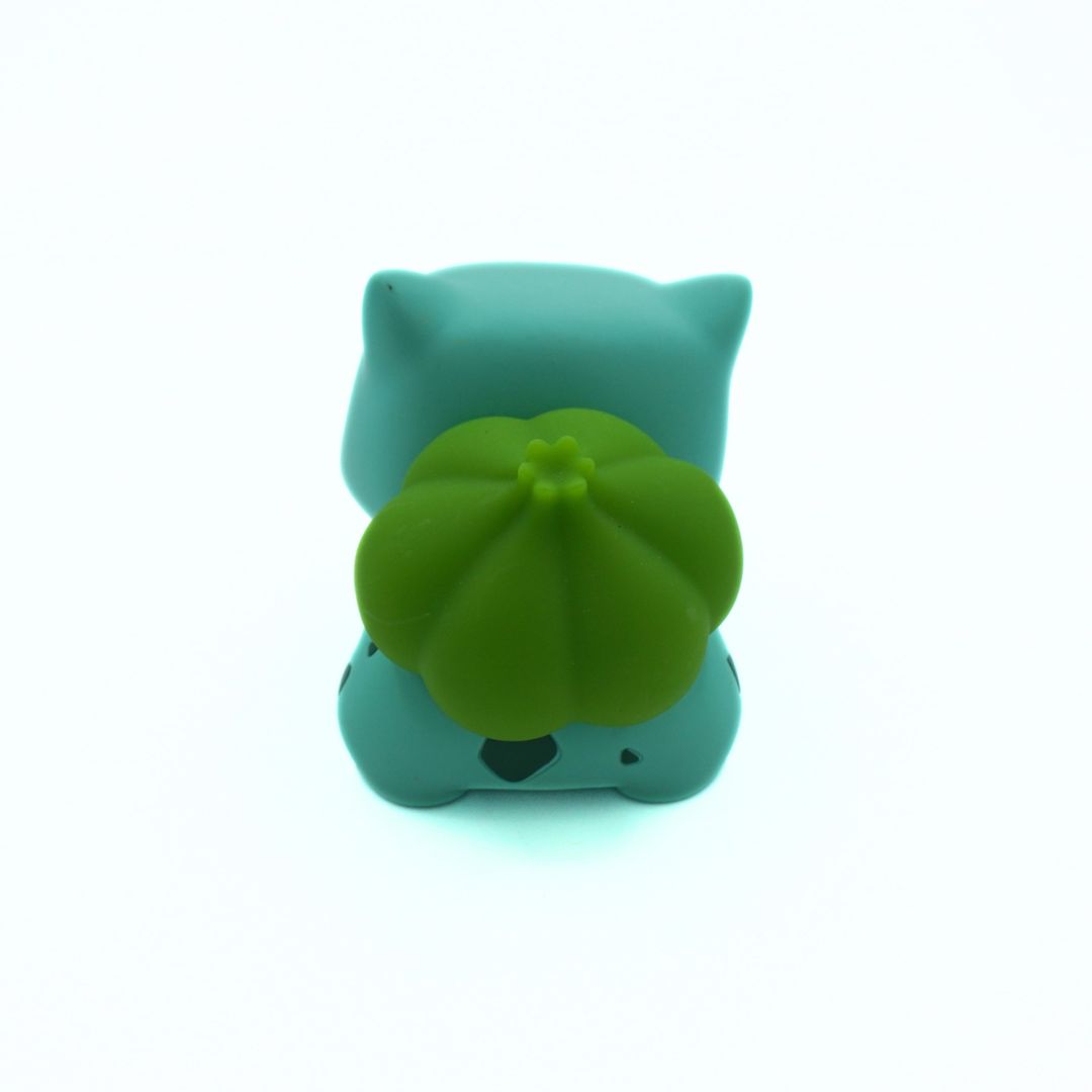 Green cat-shaped vinyl figure with a green cap on a white background