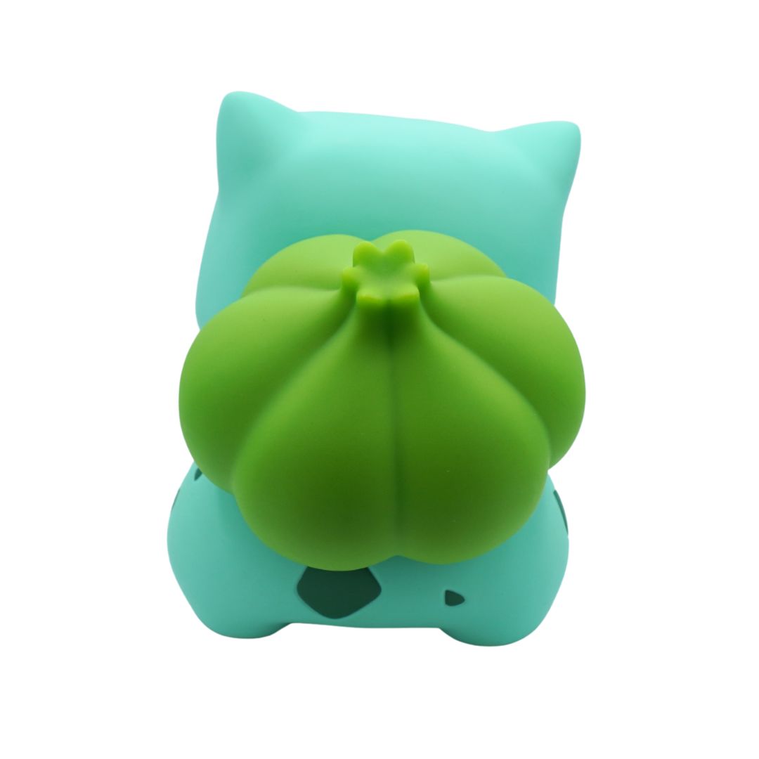 Green and blue plush toy with a pumpkin-like design on a white background