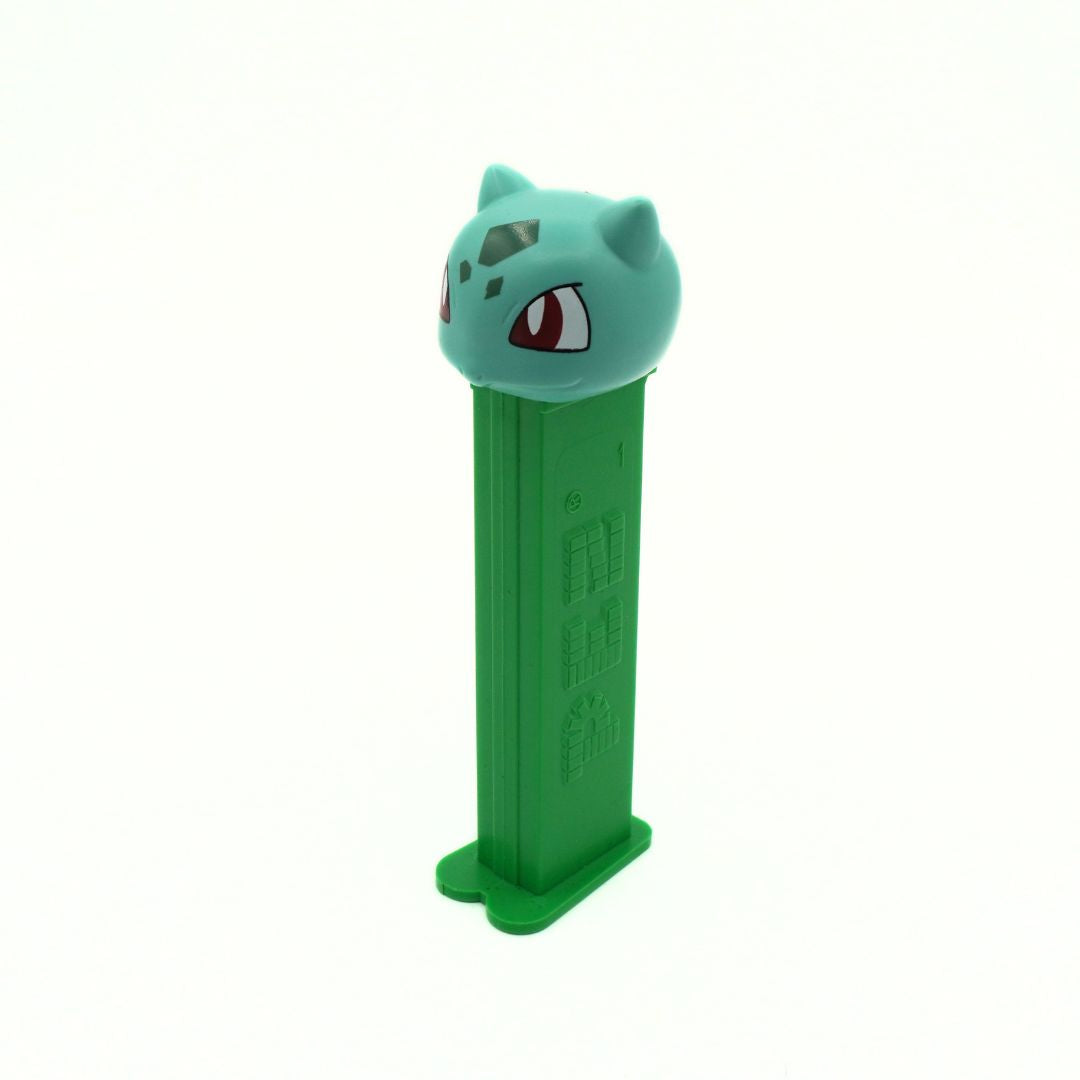 Green toy figure with a cat-like face on a white background