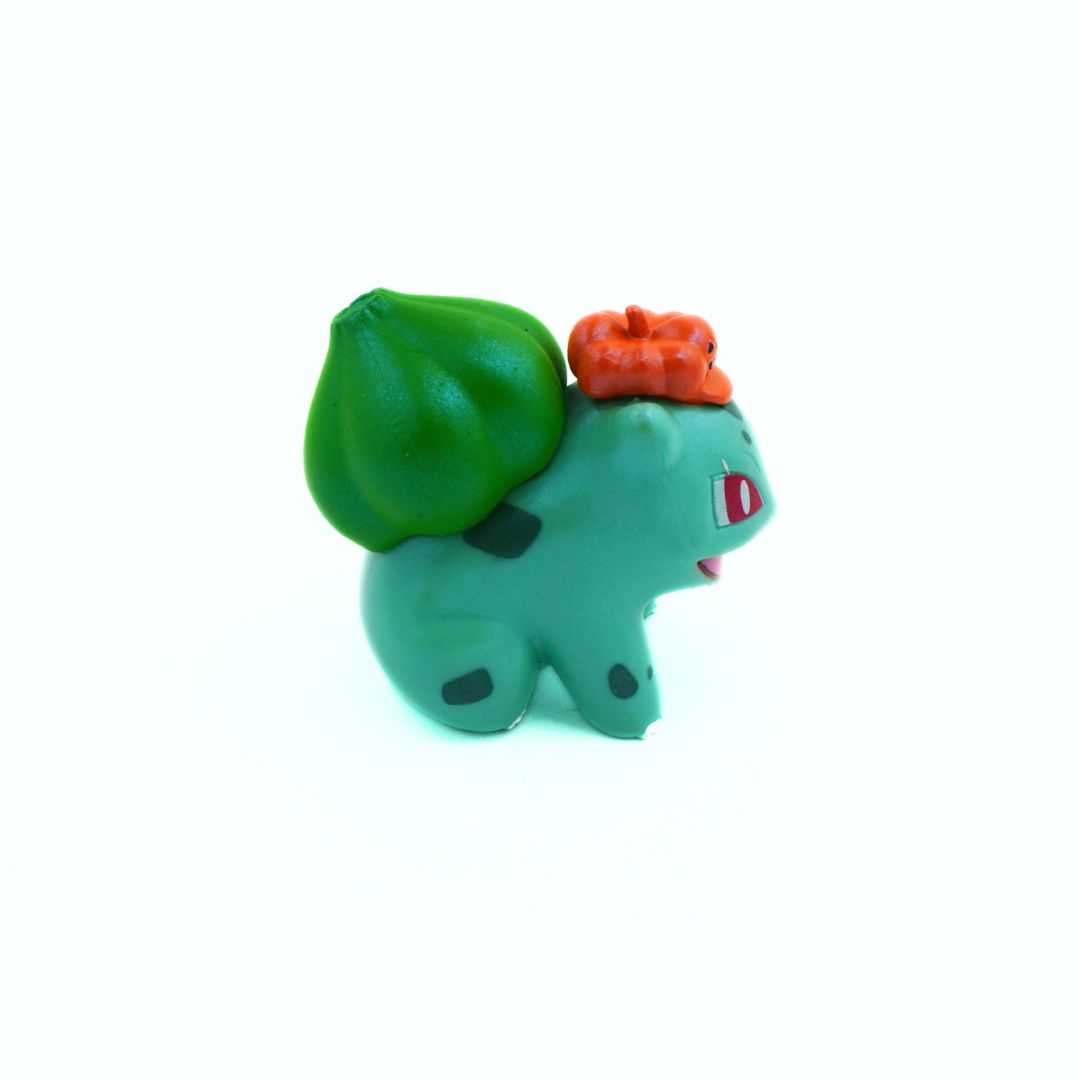 Small green toy figure with a red hat on a white background