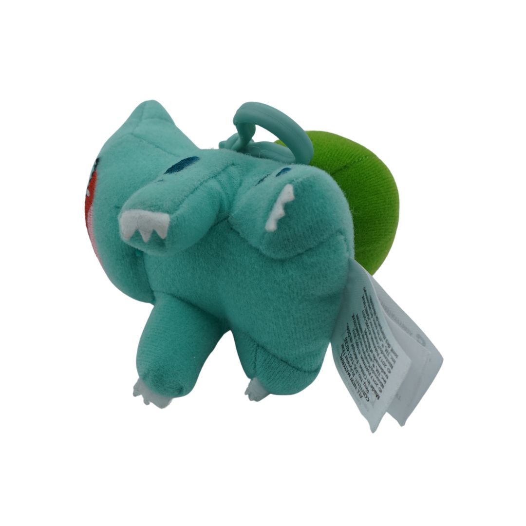 Small green plush toy with a tag on a white background