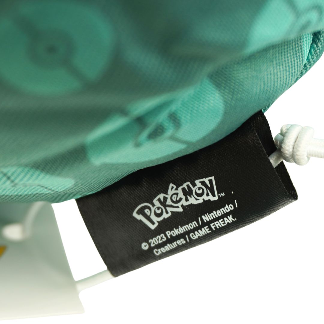 Close-up of a Pokémon branded tag on a green fabric background