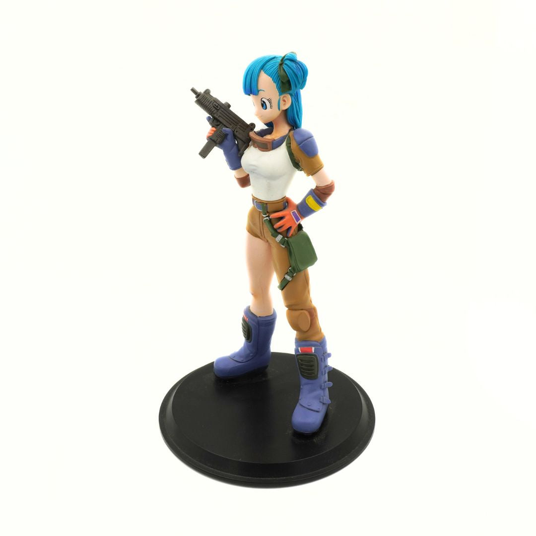 A collectible anime figurine of a female character with bright blue hair, wearing a white tank top, brown pants, and blue boots, holding a black submachine gun while standing on a round black display base against a plain white background.