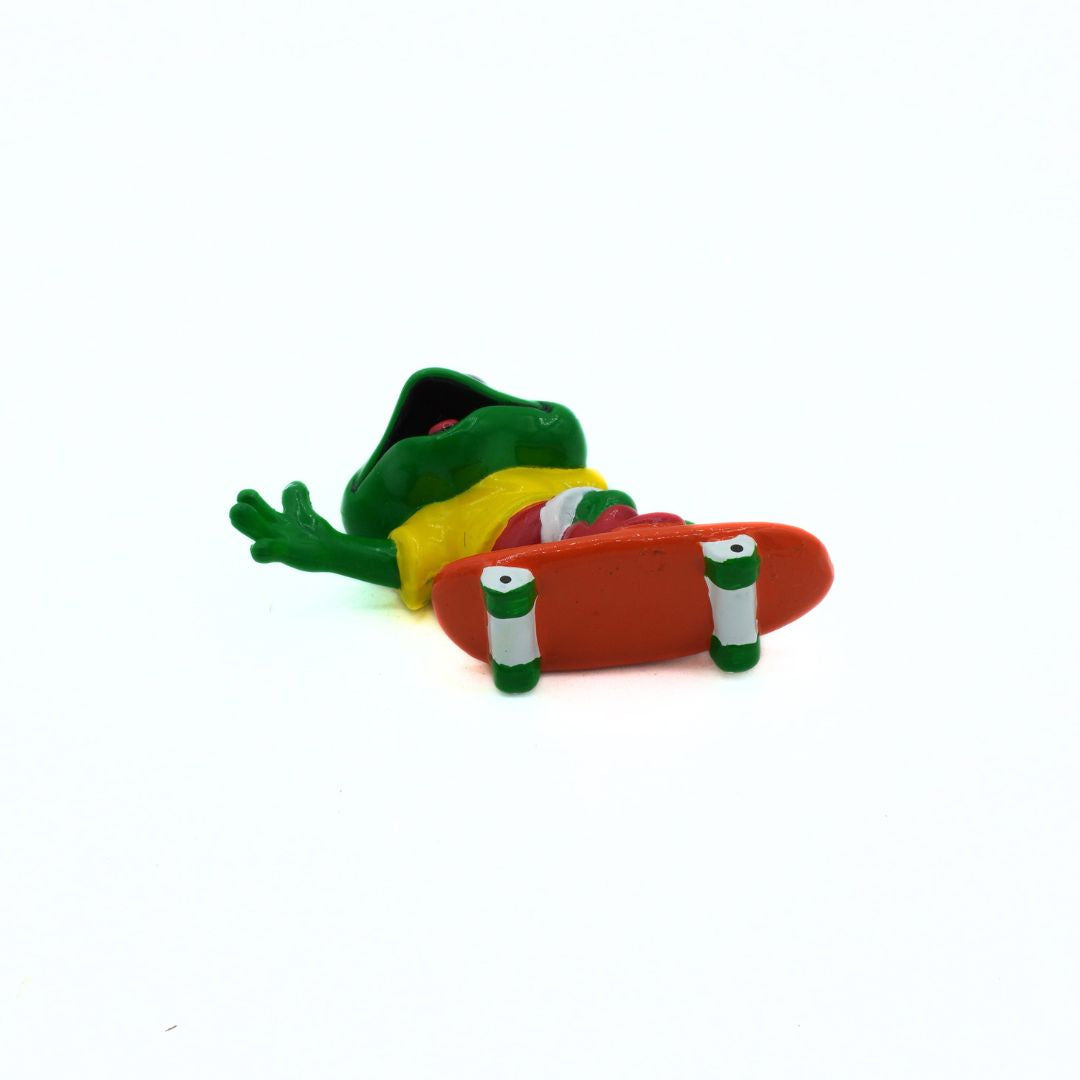 Colorful frog figurine with a skateboard on a white background