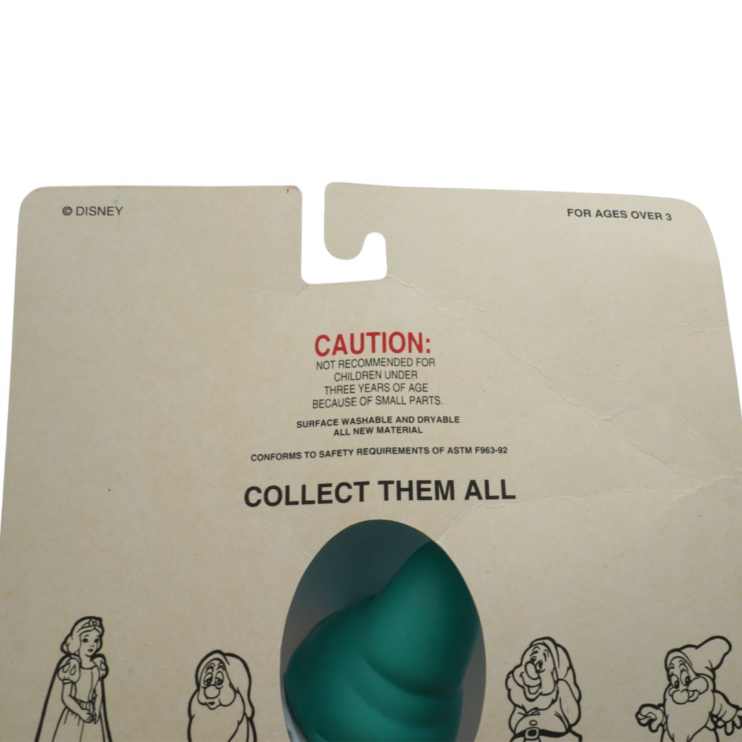 Toy packaging with Disney branding and a teal object inside, featuring a 'Collect Them All' message.