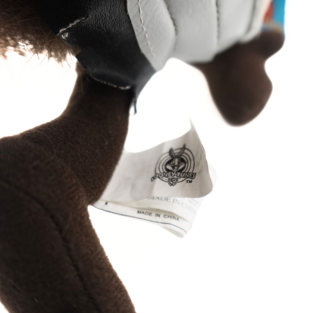 Close up of the care tags on the leg of the 90's Tasmanian Devil Knight plush from Looney Tunes