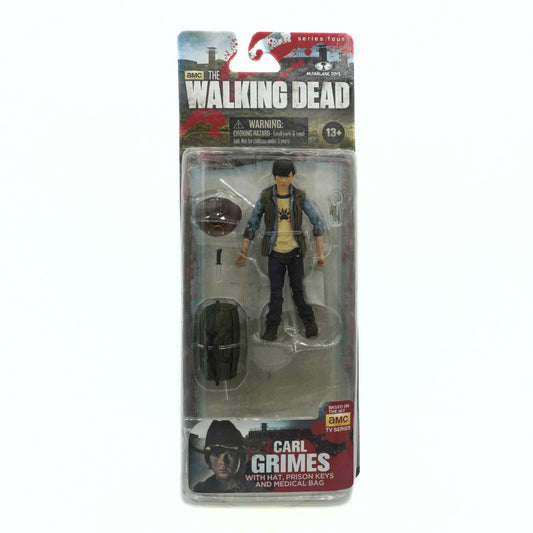 Action figure of Carl Grimes from 'The Walking Dead' series in packaging on a white background