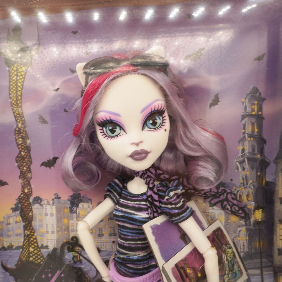 Monster High doll with cat ears against a spooky town backdrop