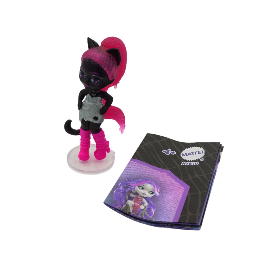Small Catty Noir doll with pink hair and a black pamphlet on a white background