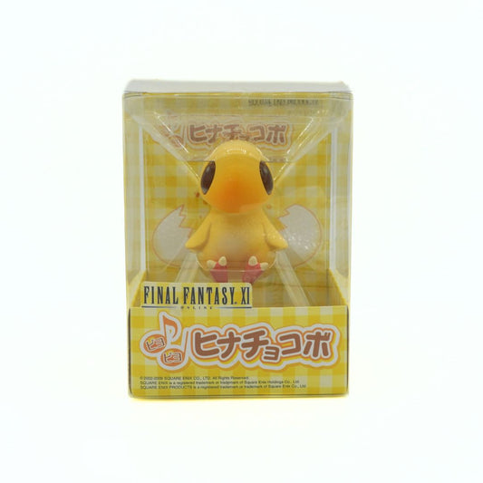 Yellow figurine in a clear box with 'Final Fantasy XI' branding on a white background