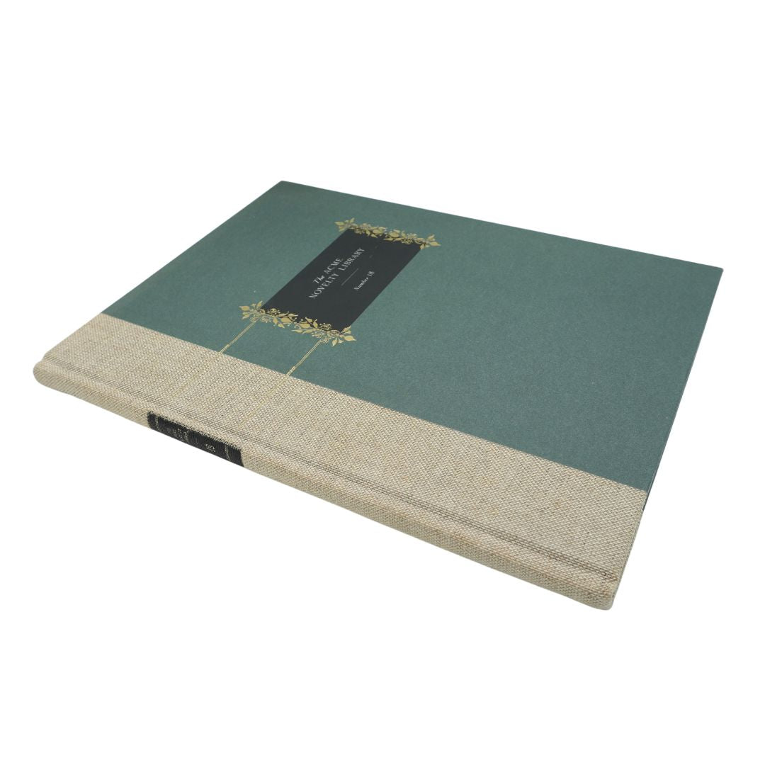 A hardcover book with a dark teal-green cover, a textured beige linen-style lower band, and a black central label with gold floral detailing, shown on a plain white background.
