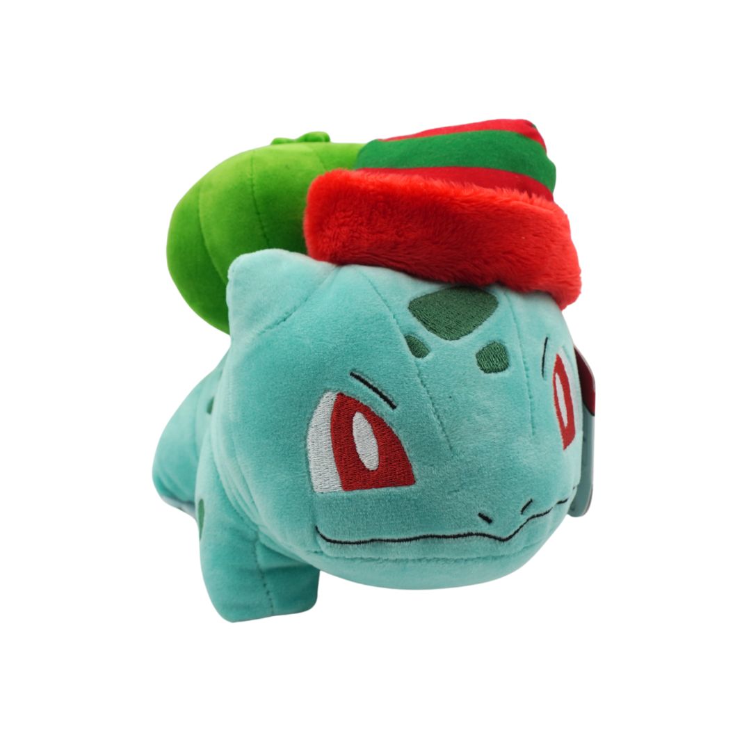 Plush toy of a character with a green body and red hat on a white background