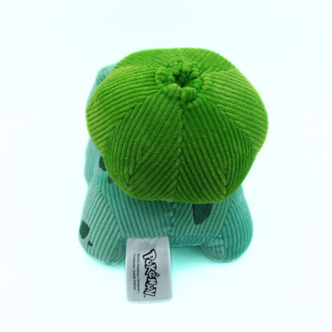 Green plush toy with a tag on a white background