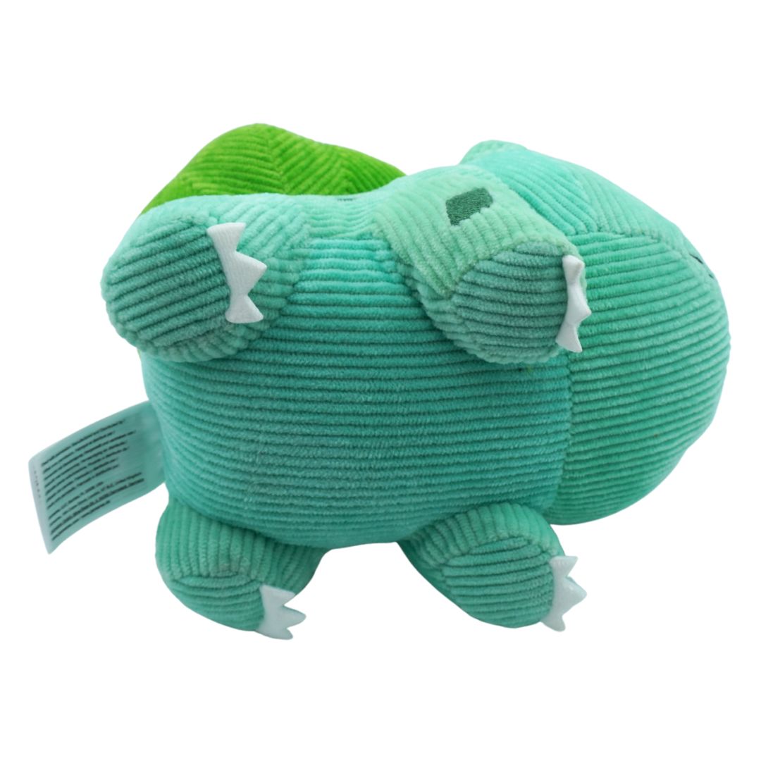 Green plush toy with white accents on a white background