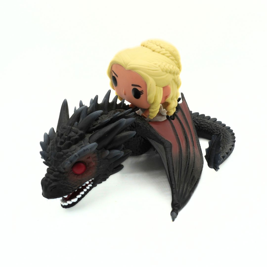 A stylized collectible figure of a blonde woman riding a black dragon on a plain white background.