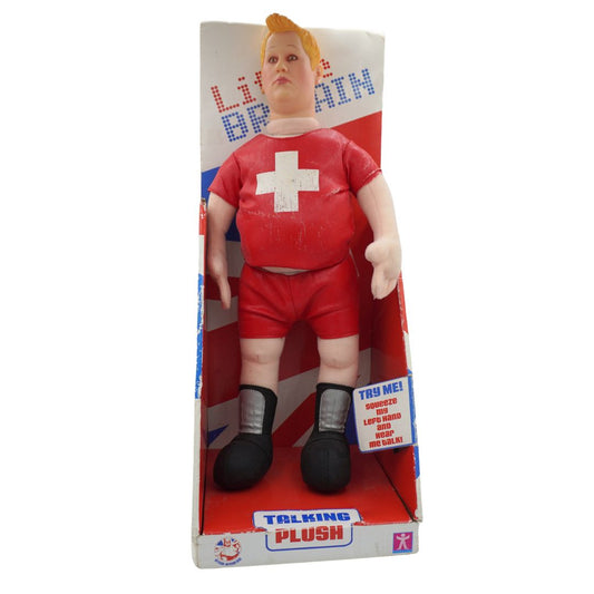 A vintage Talking Plush collectible doll of a buff man in a red athletic outfit with a white cross on the chest, displayed inside its original retail packaging.