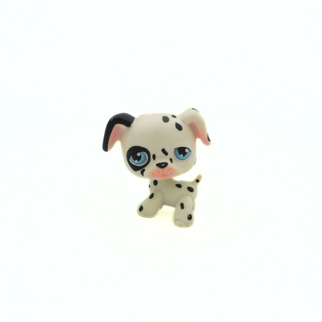 Small toy dog figurine with black spots on a white background