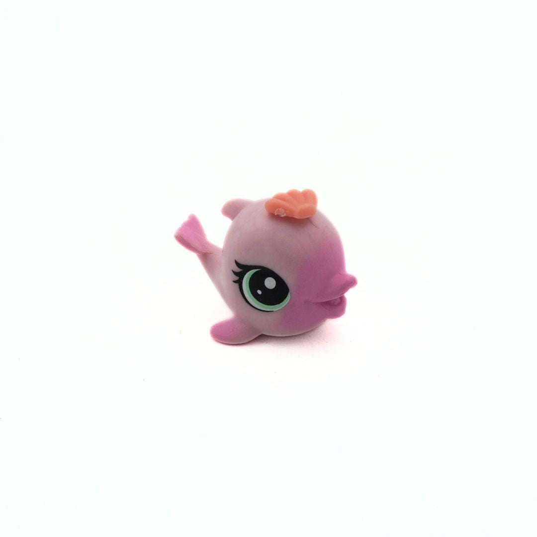Pink toy figure with a small orange object on a white background