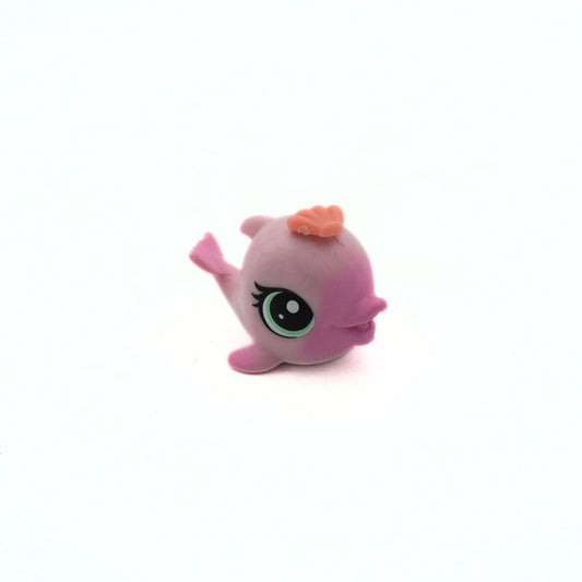 Pink toy figure with a small orange object on a white background