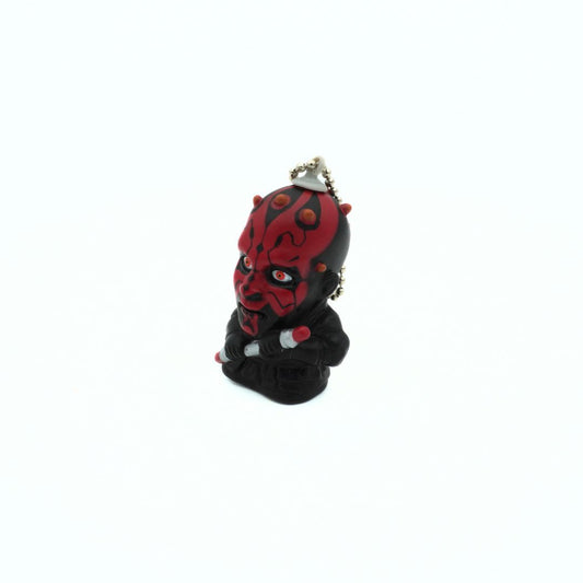 A vintage Star Wars Darth Maul keychain holding his dual ended lightsaber