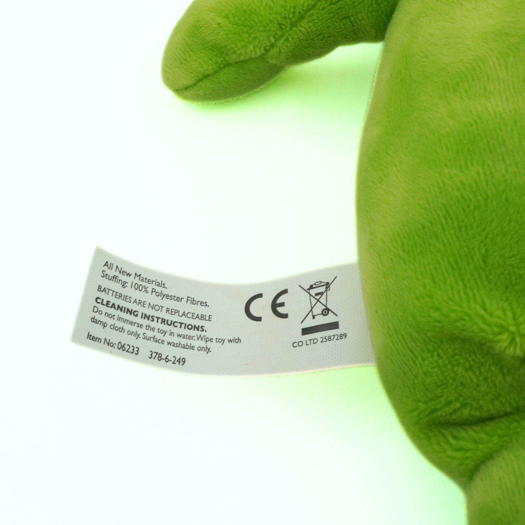 Green plush toy with a label on a white background