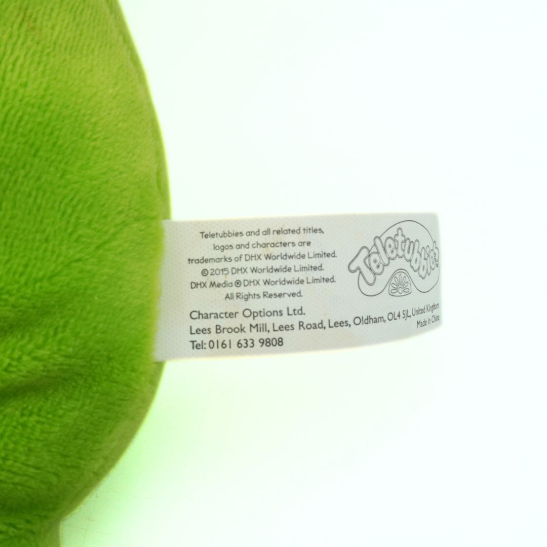 Close-up of a green plush toy with a label on a white background