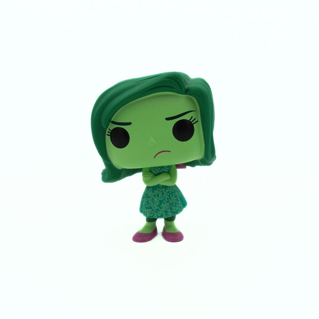 Green character figurine with a sad expression on a white background