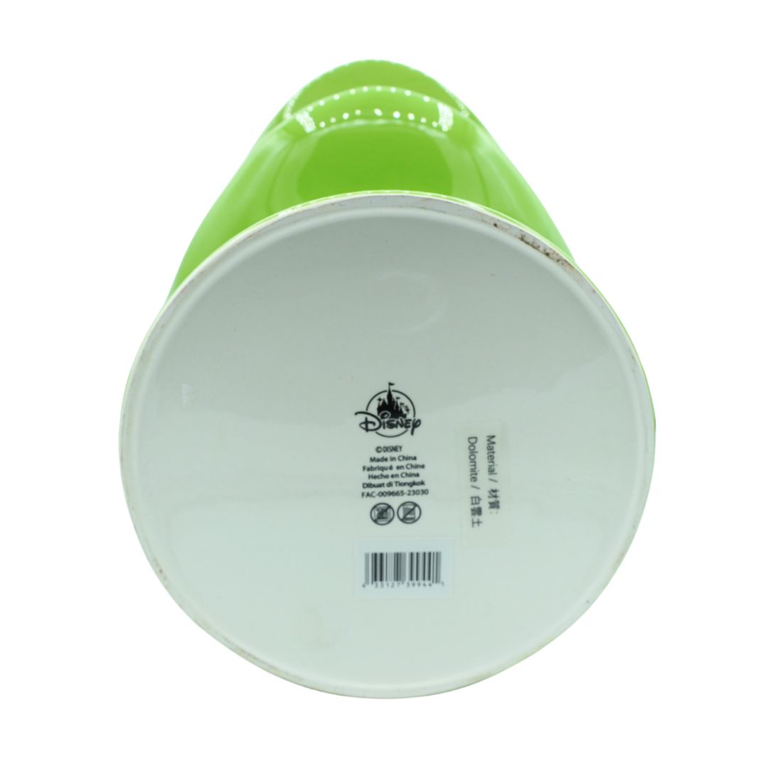 The bottom of a ceramic Disney mug in bright green, showing the white glazed base with printed Disney text and a barcode.