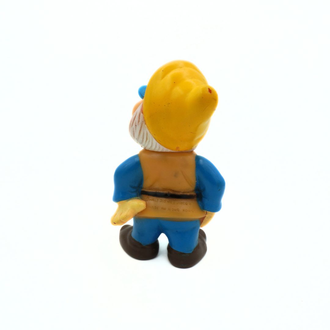 Toy figure of a dwarf in a blue outfit with a yellow hat on a white background