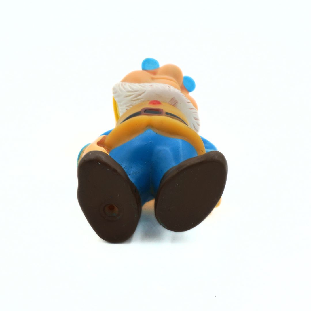 Toy figure of a character with blue pants and brown shoes on a white background