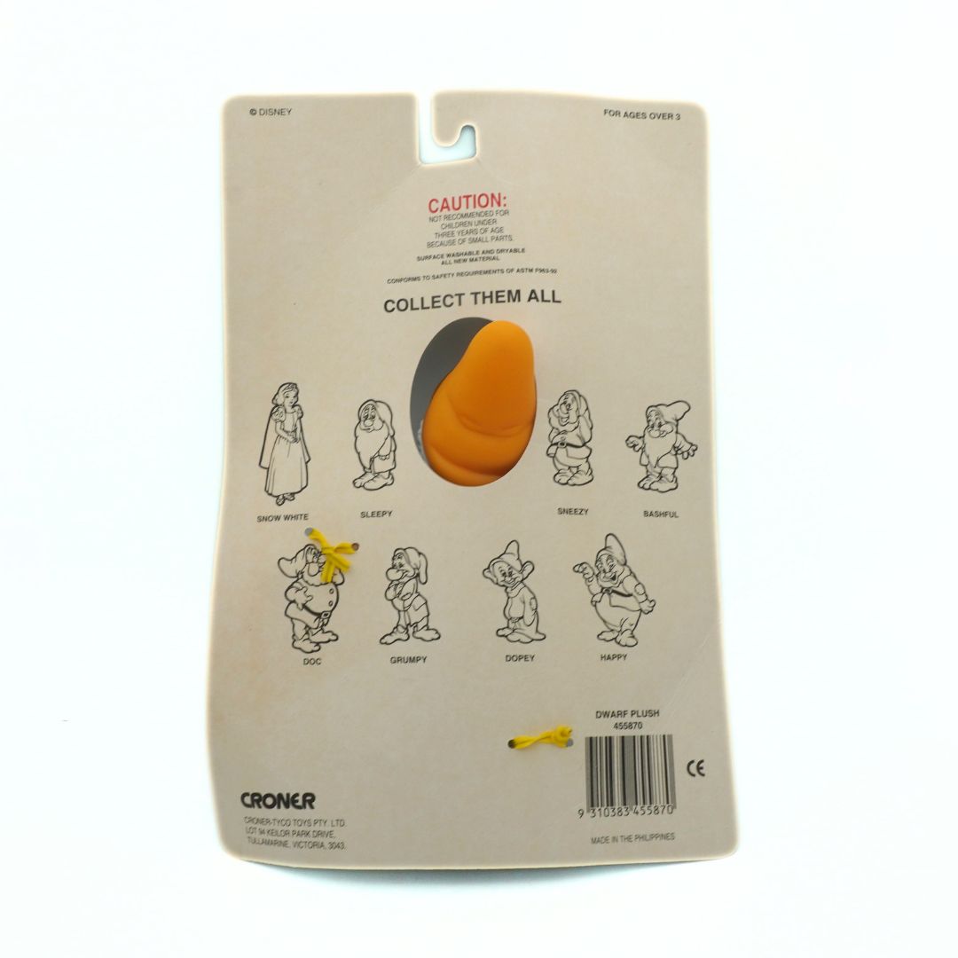 Toy packaging with character illustrations and a caution label on a beige background