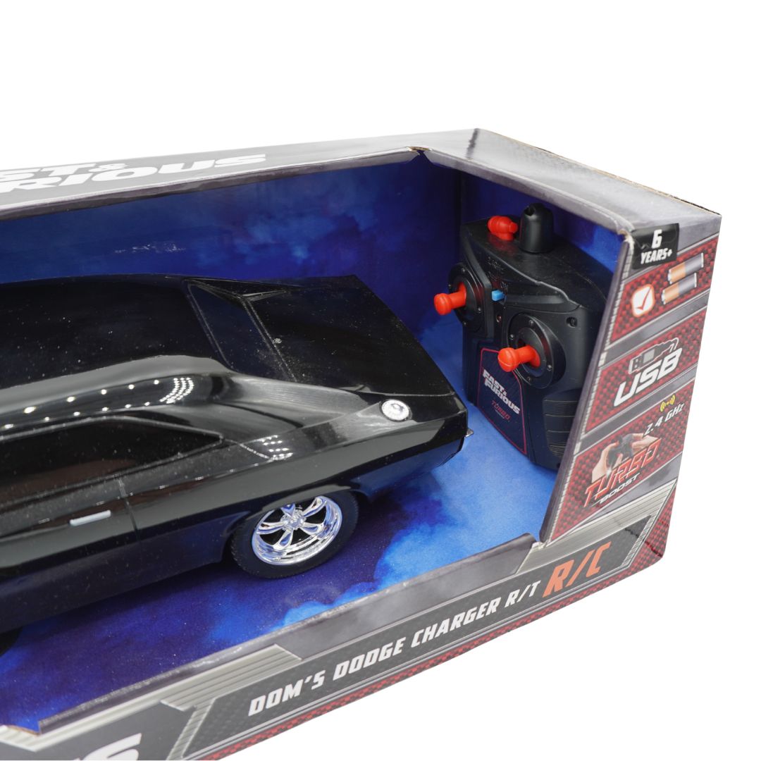 A boxed remote control toy car set featuring a black muscle car model and a black handheld controller with red joysticks, shown inside retail packaging on a white background.