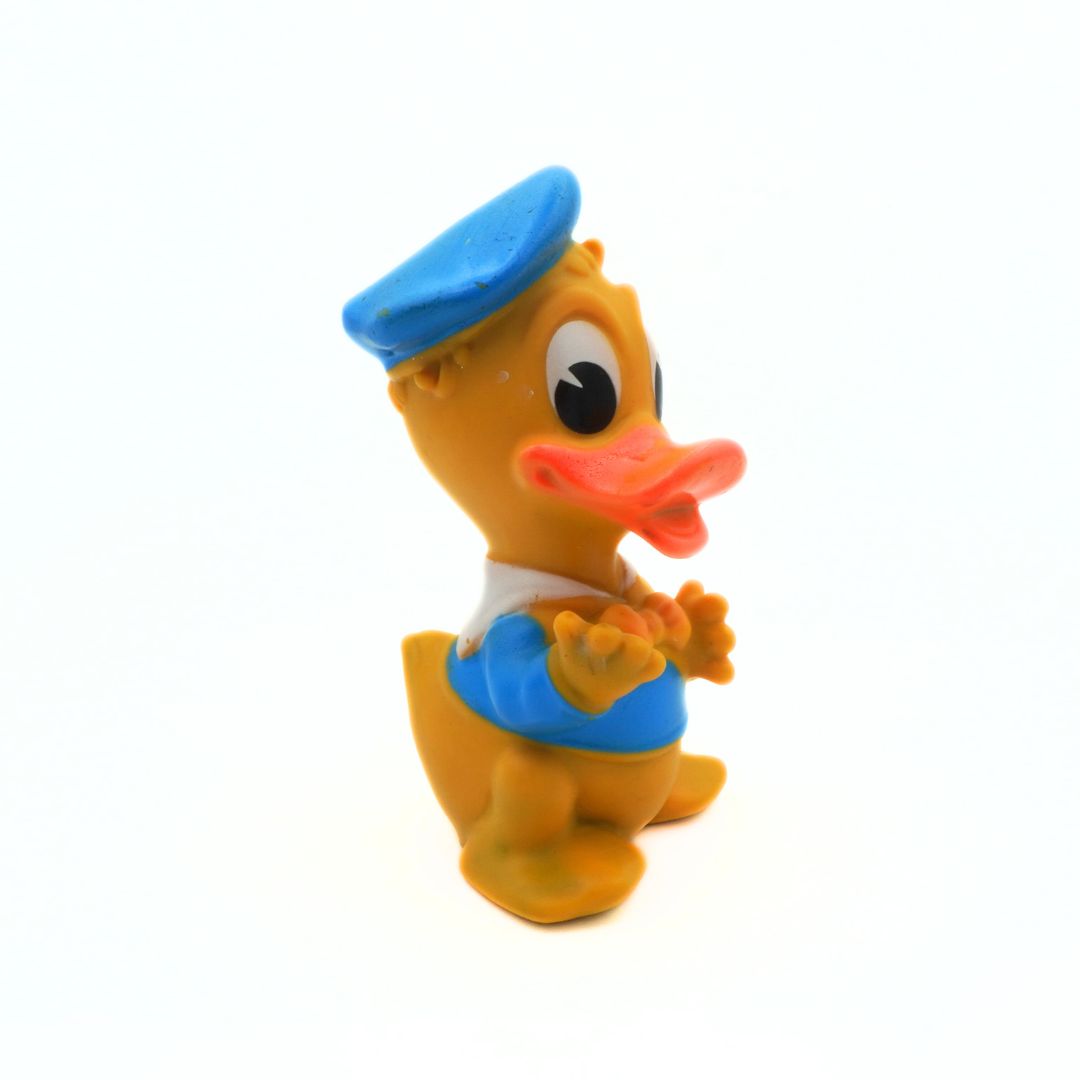 Toy duck figure with a blue cap on a white background