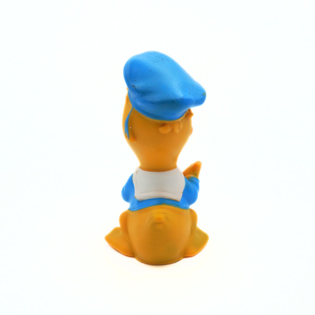 Toy figure of a character with a blue hat and outfit on a white background