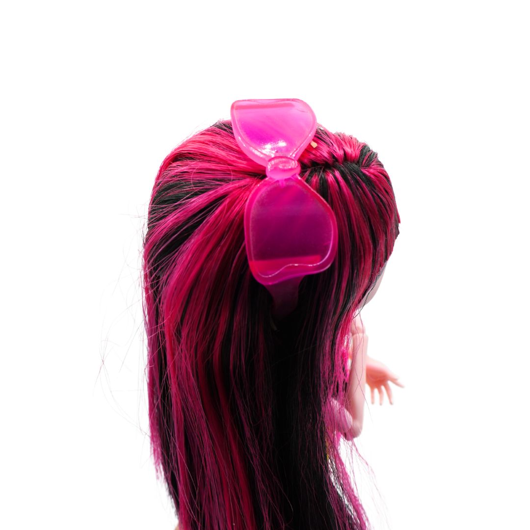 Top down photo of a 2010 Monster High Draculaura from the Gloom Beach range with black and pink hair and pink sunglasses, photographed on a black stand on a white background