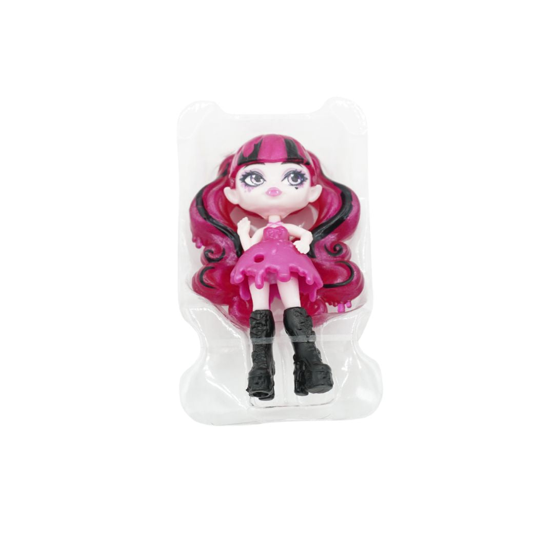 Monster High collectible doll in its clear plastic blister packaging, featuring a character with pink and black hair, a pink dress, and black boots.