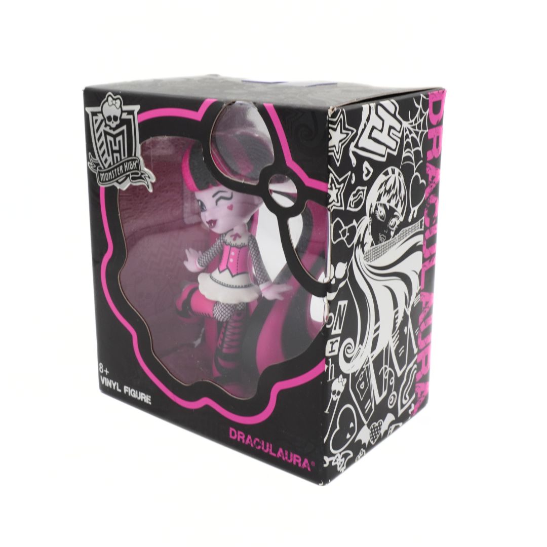 Box packaging of a Draculaura figure from Monster High with black, pink, and white design.