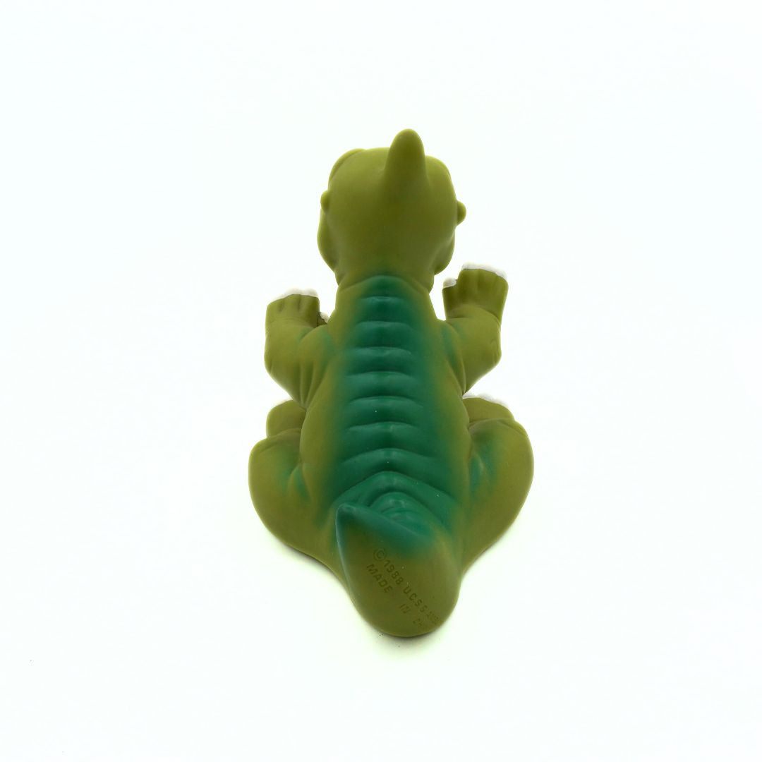 Green dinosaur-shaped toy on a white background