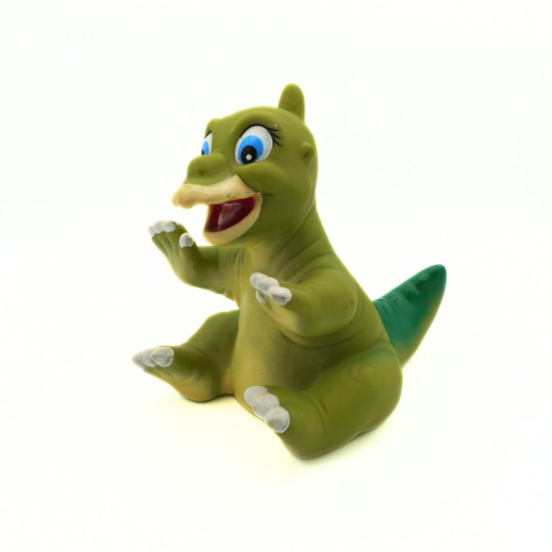 Green dinosaur toy with blue eyes on a white background