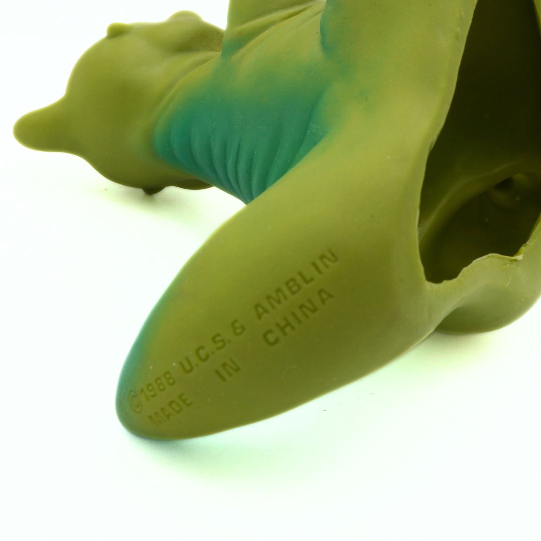 Close-up of a green rubber Duckie with 'U.C.S.G. Amblin' text on a white background
