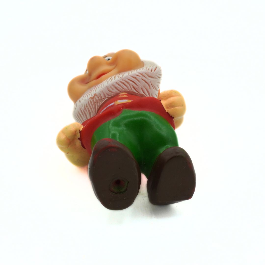 Toy figure of a character with green pants and red shirt on a white background