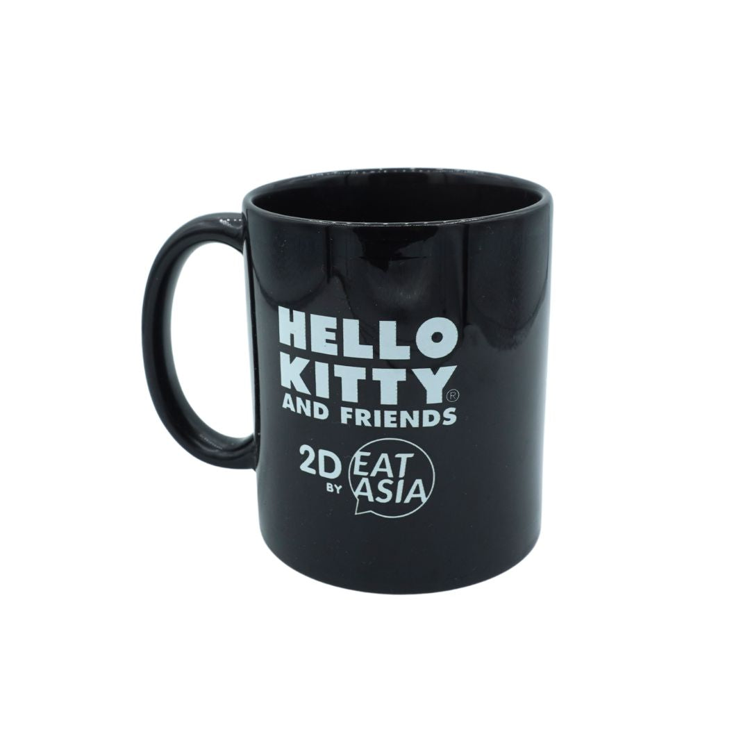 A glossy black ceramic mug featuring the white printed text 'HELLO KITTY AND FRIENDS' and '2D EAT ASIA' on the front, set against a plain white background.