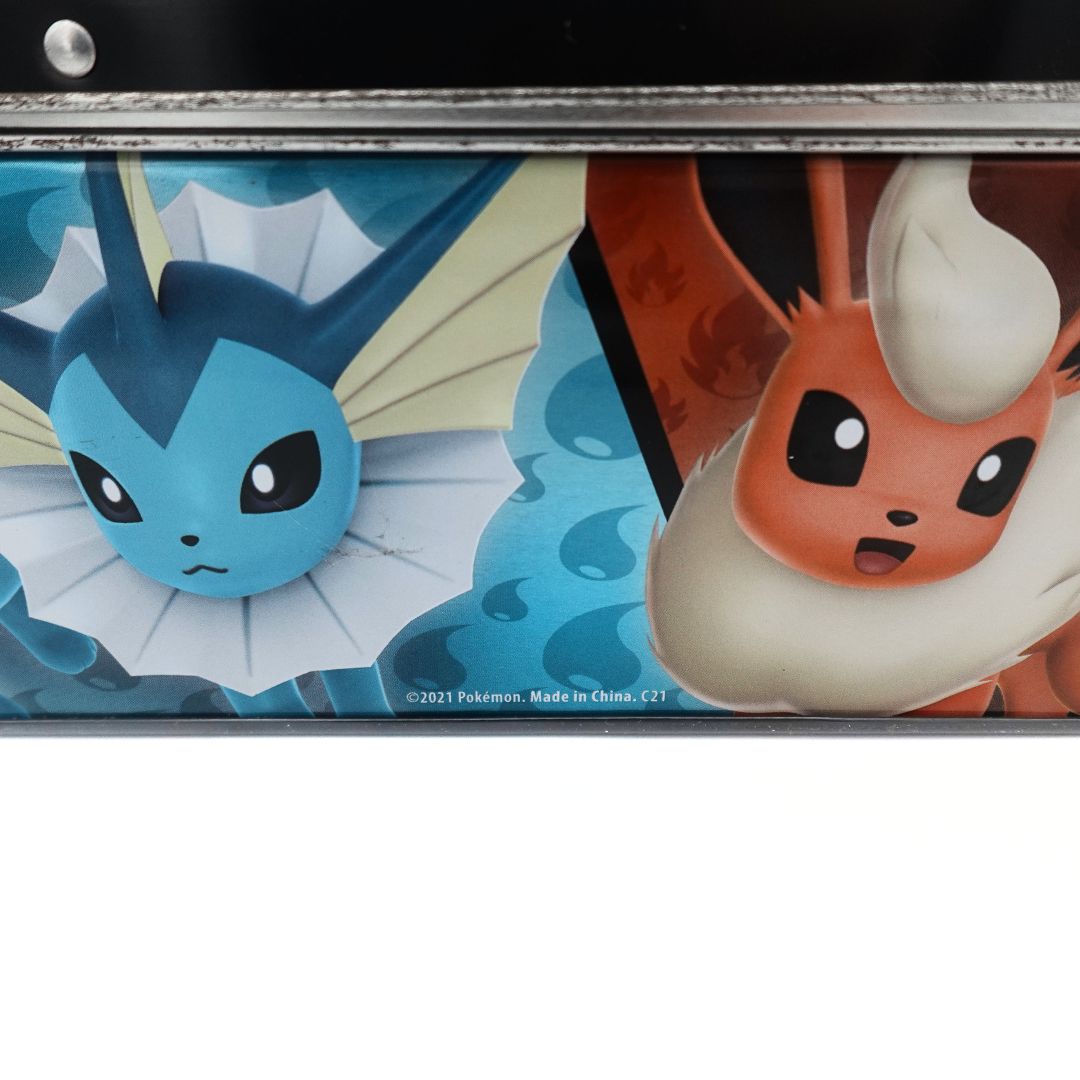 Closeup of the underside of the 2021 Pokemon Eeveelution lunchbox showing Vaporeon, Flareon, the copyright information and some wear to the metal trim