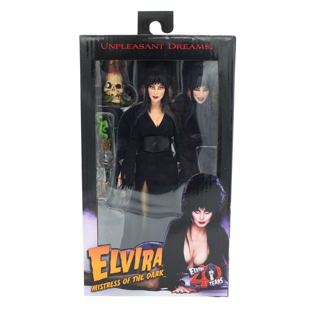 Elvira Mistress of the Dark action figure in its original packaging, featuring a black and white design with accessories visible through the clear window.