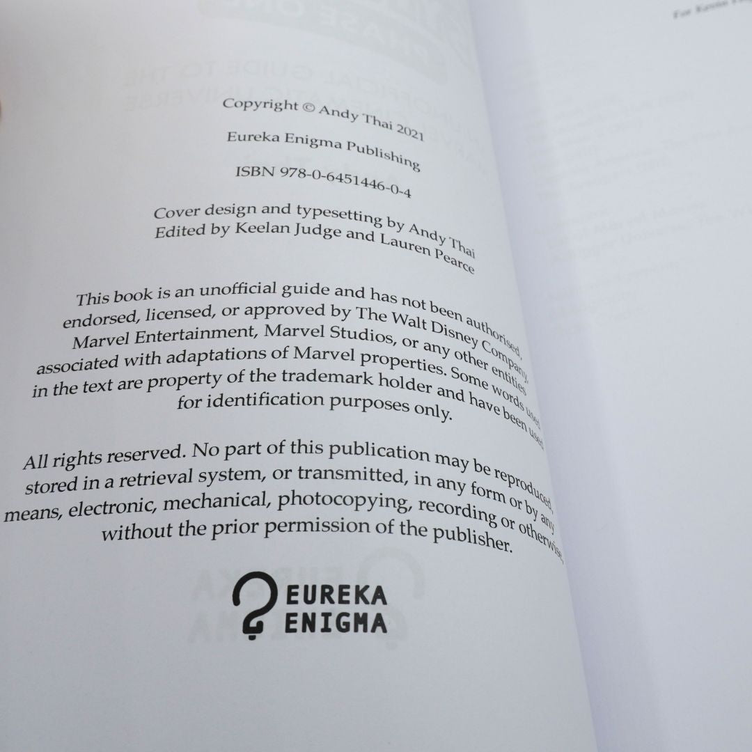 A close-up of an open book's printed copyright page showing publisher text for Eureka Enigma Publishing, including ISBN 978-0-6451446-0-4, cover design credits, and the Eureka Enigma logo at the bottom.