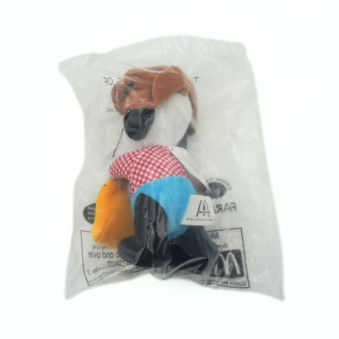 Plush toy dog in a plastic bag with visible branding on a white background