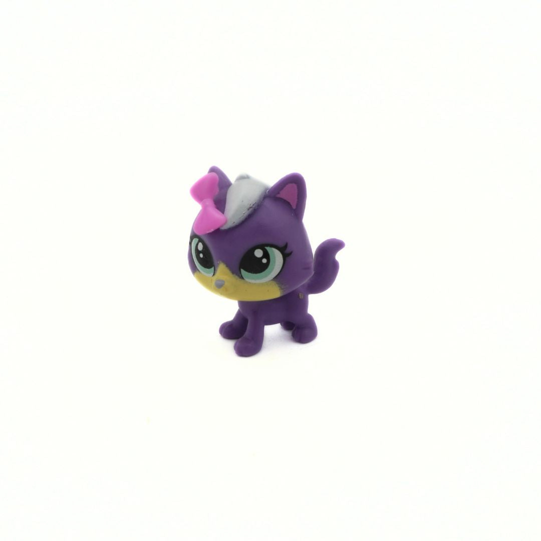 Purple toy cat figure with a pink bow on a white background